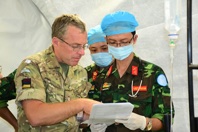 Nhân viên Bệnh viên dã chiến và chuyên gia quốc tế trao đổi nghiệp vụ trước ca mổ.